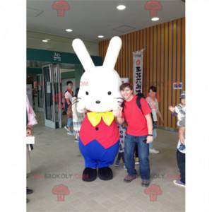 Weißes Kaninchenmaskottchen im roten und blauen Outfit -