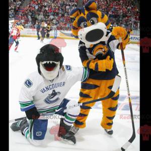 2 mascots a yellow and blue tiger and an orca a black shark -