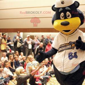 Black and yellow bear mascot in white outfit - Redbrokoly.com