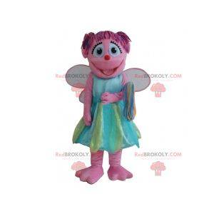 Glimlachende roze fee mascotte met een kleurrijke jurk -