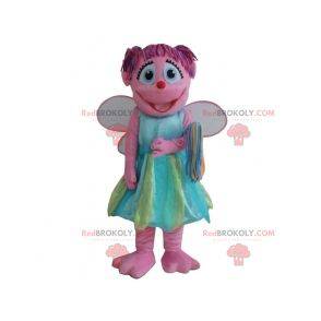 Mascote fada rosa sorridente com um vestido colorido -