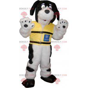 Mascota de perro peludo blanco y negro con un chaleco amarillo