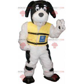 Mascota de perro peludo blanco y negro con un chaleco amarillo