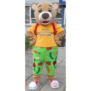 Bear mascot in green and yellow outfit. Red cross mascot -