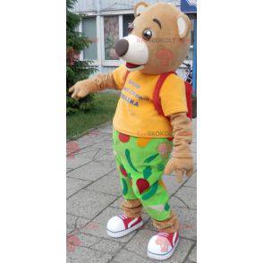 Mascota del oso en traje verde y amarillo. Mascota de la cruz