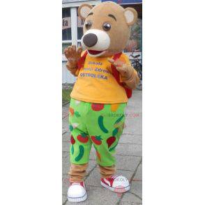 Bear mascot in green and yellow outfit. Red cross mascot -
