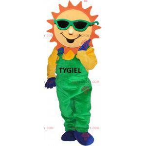 Mascotte de soleil habillé d'une salopette verte -