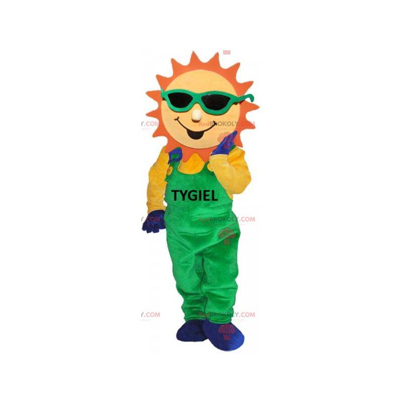 Mascotte de soleil habillé d'une salopette verte -