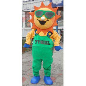 Mascotte de soleil habillé d'une salopette verte -