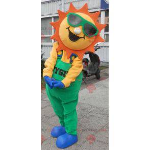 Mascotte de soleil habillé d'une salopette verte -