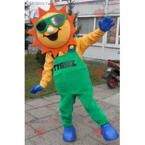 Mascotte de soleil habillé d'une salopette verte -