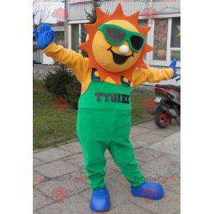Mascotte de soleil habillé d'une salopette verte -