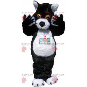 Schwarzweiss-Katzenmaskottchen mit orangefarbenen Augen -