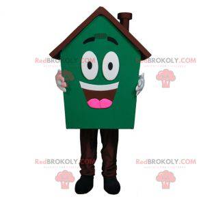 Mascote gigante da casa muito sorridente verde e marrom -