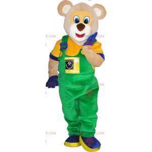 Mascote urso bege vestido com uma roupa colorida -