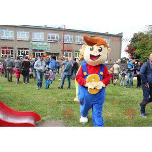 Mascotte de jeune garçon souriant habillé d'une salopette -