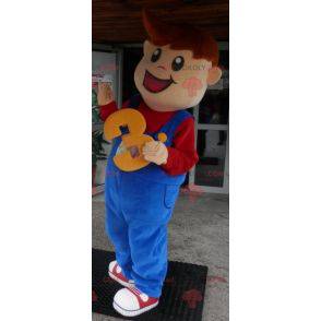 Menino mascote sorridente vestido de macacão - Redbrokoly.com