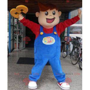 Menino mascote sorridente vestido de macacão - Redbrokoly.com