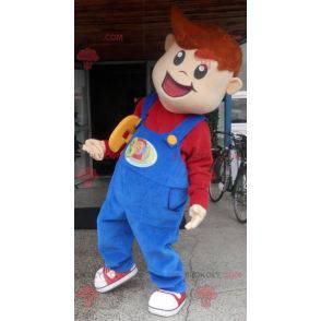 Menino mascote sorridente vestido de macacão - Redbrokoly.com