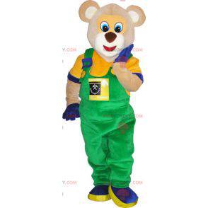 Teddy bear mascot in overalls and colorful outfit -