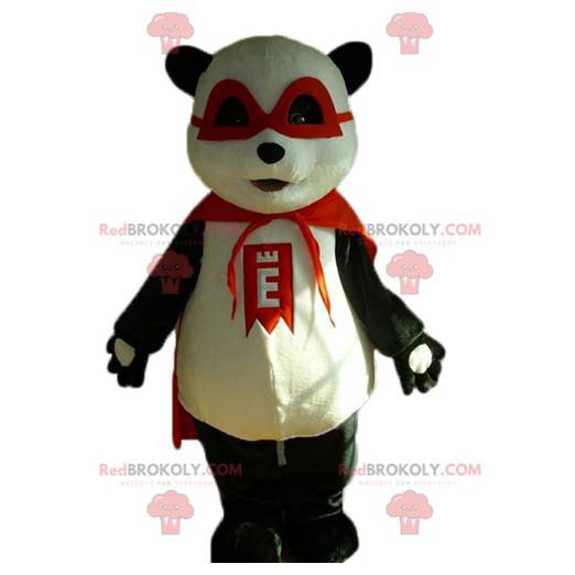 Czarno-biała maskotka panda z maską i czerwoną peleryną -