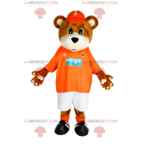 Mascota del oso de peluche con gorra y ropa deportiva. -