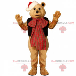 Mascota del oso de peluche con un lazo y un sombrero de Navidad