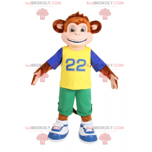 Mascot liten ape som smiler i grønne Bermuda shorts -