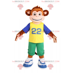 Mascot little monkey smiling in green Bermuda shorts -