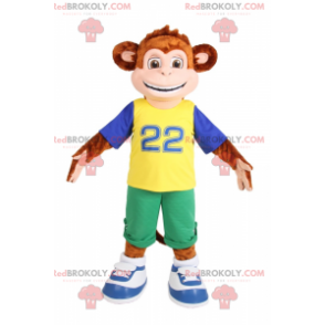 Mascot liten ape som smiler i grønne Bermuda shorts -