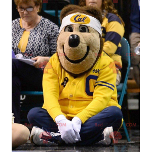 Medvěd hnědý maskot v žluté a modré sportovní oblečení