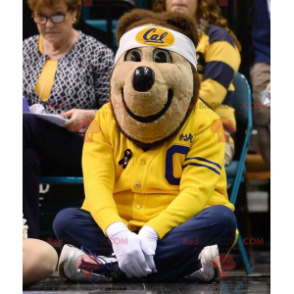 Mascotte orso bruno in abbigliamento sportivo giallo e blu -