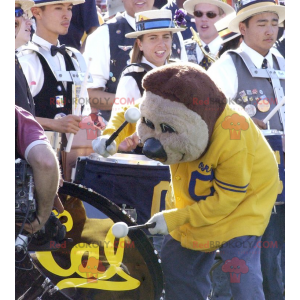 Mascota del oso pardo en ropa deportiva amarilla y azul -