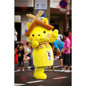 Mascotte de chat jaune avec un toit de maison sur la tête -