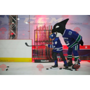 Mascotte d'orque noir et blanc en tenue de hockey -