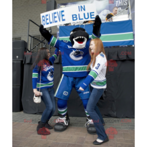 Black and white killer whale mascot in hockey gear -