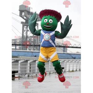 Mascotte d'artichaut vert et rouge en tenue bleue et jaune -