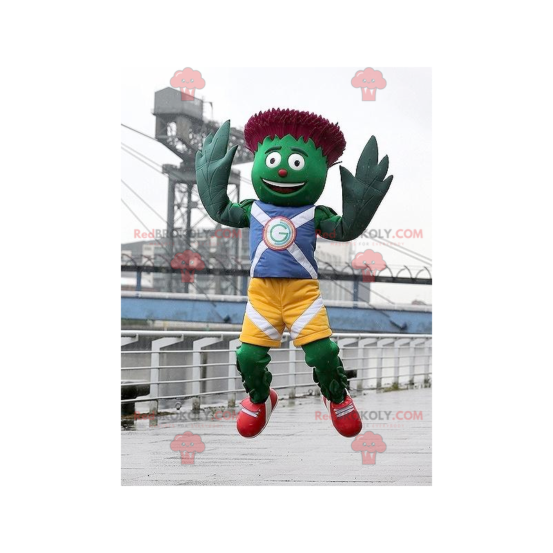 Mascotte d'artichaut vert et rouge en tenue bleue et jaune -