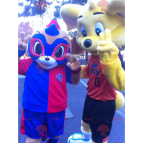 2 maskoter: en gul bjørn og et blått og rødt maskert dyr -