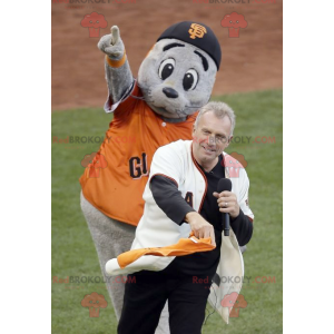 Mascota de león marino gris con una camiseta naranja -