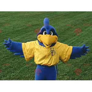 Blaues und gelbes Vogelmaskottchen in der Sportbekleidung -