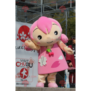 Mascotte de fillette avec les cheveux et une robe rose -