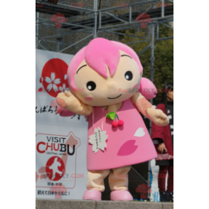 Mascotte de fillette avec les cheveux et une robe rose -