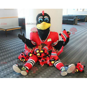 Mascotte d'oiseau noir et blanc avec une tenue de sport rouge -