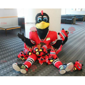 Mascote pássaro preto e branco com roupa esportiva vermelha -