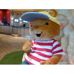 Mascota del oso de peluche marrón con una camiseta y una gorra