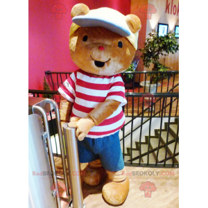 Mascota del oso de peluche marrón con una camiseta y una gorra