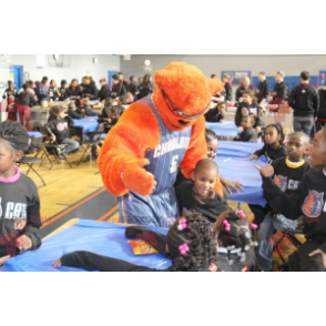 Mascote urso laranja com óculos e roupa de basquete -