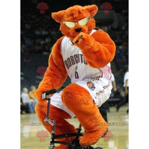 Orange bear mascot with glasses in basketball outfit -