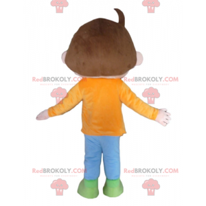 Mascote menino marrom com uma roupa laranja azul e verde -